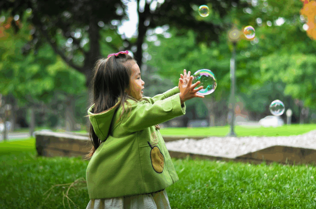 A child playing with bubbles outdoors
