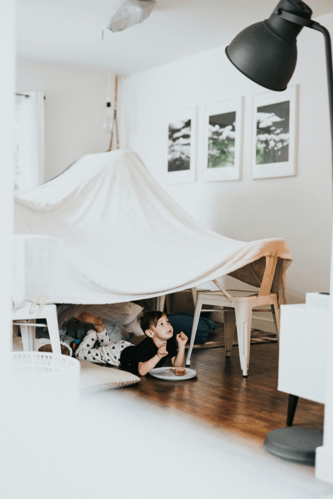 A child under a bedsheet fort