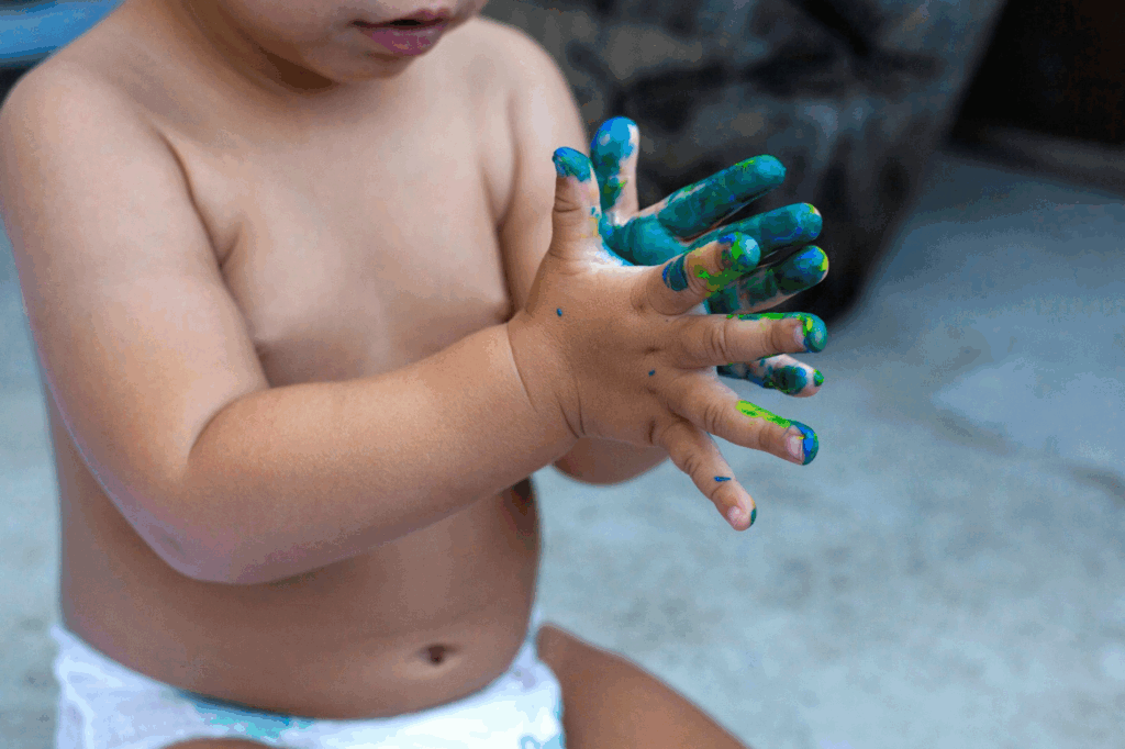 A toddler with paint on his hands