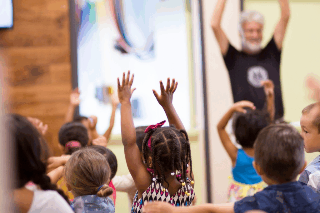 Children raising their arms in a classroom