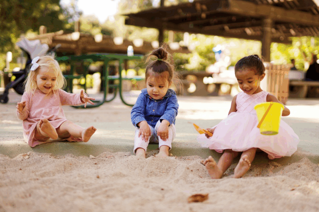 Three little girls playing in the sand