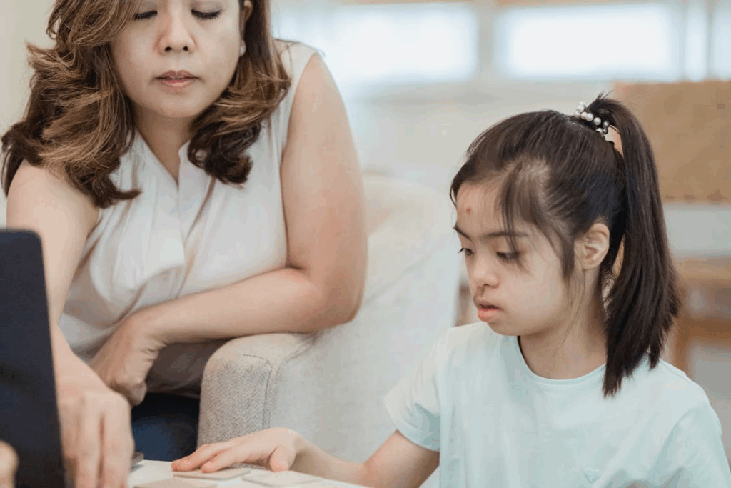 a mother and a daughter sitting together at the table and playing