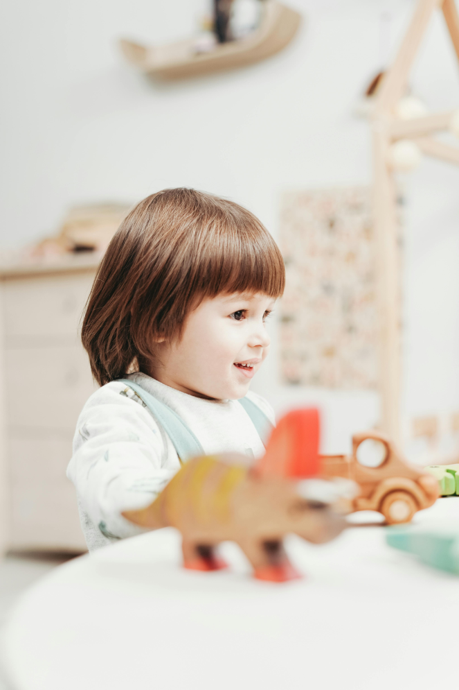 a child in a white onesie playing with toys