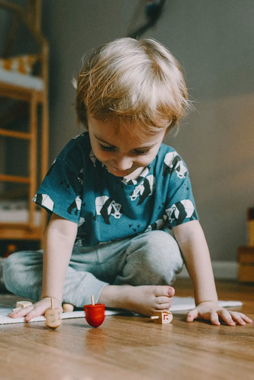 little boy sitting on the floor with his toys