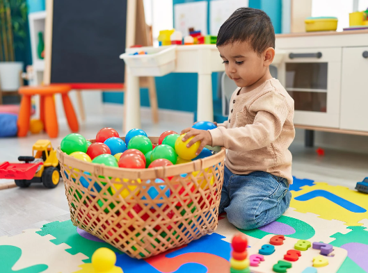 A child playing with several colored balls