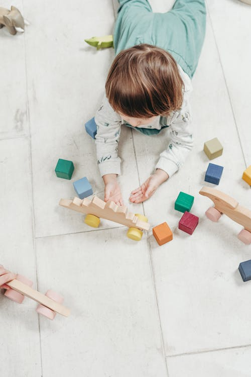A kid playing with coloured blocks