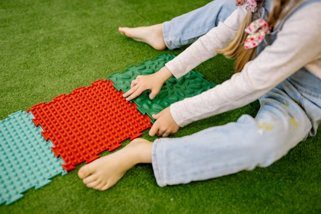 A child playing with mats of different textures